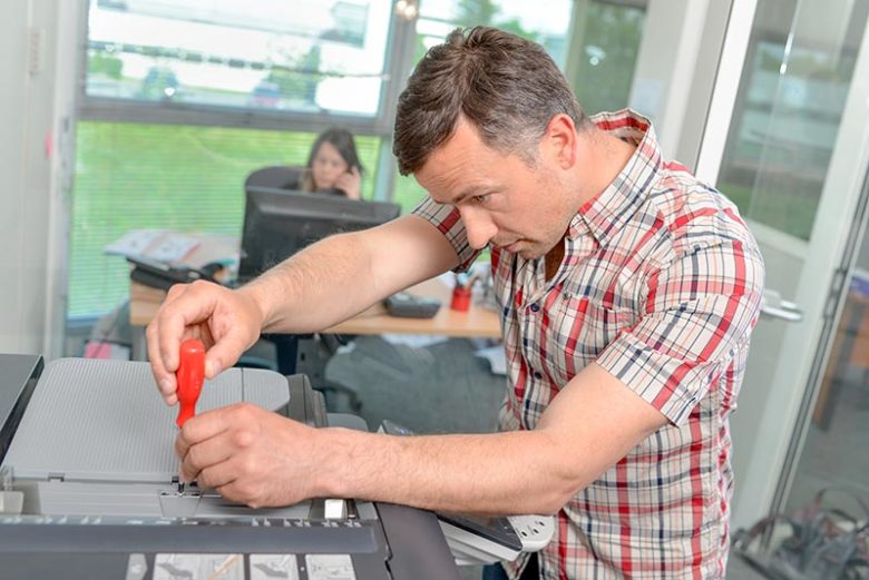 man performing printer repairs in Grand Rapids. 