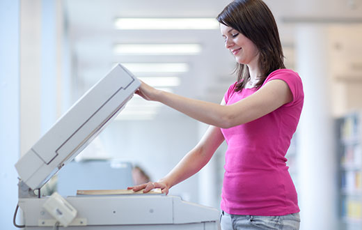 woman using a lease Copier in Grand Rapids, MN, Hoy Lakes, Aurora, MN, Biwabik, and Nearby Cities