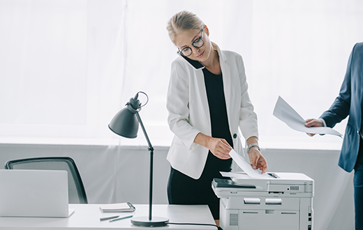 Woman at Copier Office Equipment in Grand Rapids, MN, Virginia, MN, Ely, MN, Aurora, MN, and Surrounding Areas